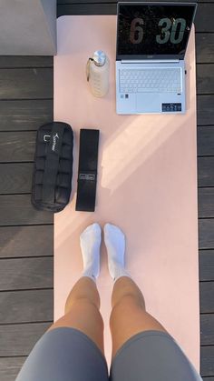 a person sitting at a table with their feet on the floor next to a laptop