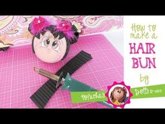 an image of hair buns being made with scissors and glue on pink mat paper