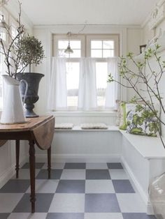 a checkered floor with vases and plants on it in front of a window