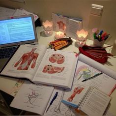 an open book sitting on top of a desk next to a laptop computer and other items