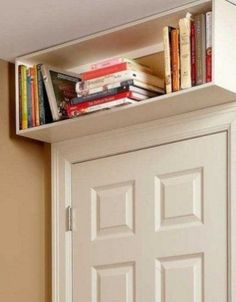 a book shelf with books on top of it next to a door in a room