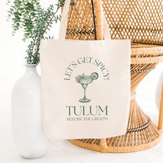 a tote bag sitting next to a vase filled with flowers