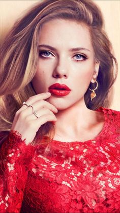 a woman in red dress posing with her hand on her chin