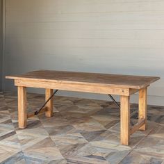 a wooden table sitting on top of a tiled floor next to a wall and door