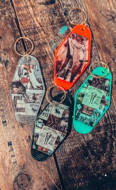 three key chains with pictures on them sitting on a wooden table