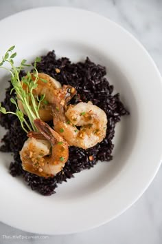 a white plate topped with rice and shrimp