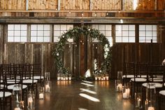 an indoor ceremony with candles and greenery on the floor, surrounded by wooden walls