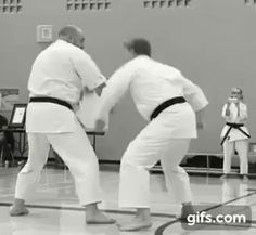 two men in white uniforms are practicing karate