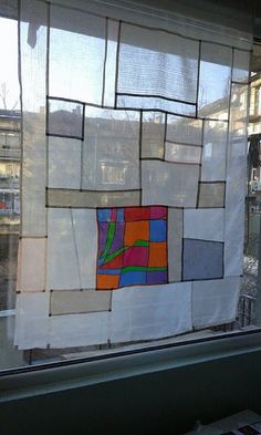 a window that has been decorated with different colored squares and lines on the outside of it