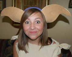 a girl wearing an angel costume with wings on her head, smiling at the camera