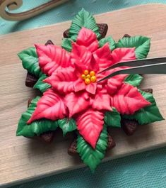 a cake decorated like a poinsettia on top of a cutting board