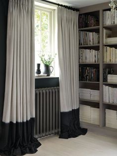 a room with bookshelves and a radiator next to the window in it