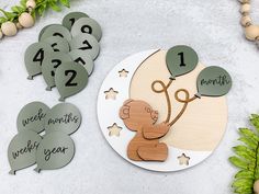 a wooden clock with numbers and a teddy bear holding a tree on it's face