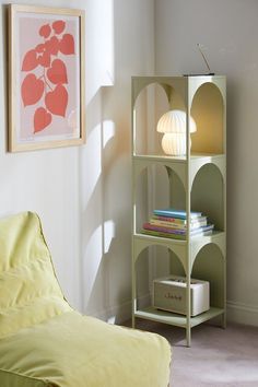 a living room with a couch and a book shelf next to a painting on the wall