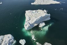 an iceberg floating in the ocean with green water