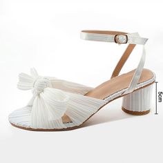 a women's white high heeled sandal with a bow at the ankle