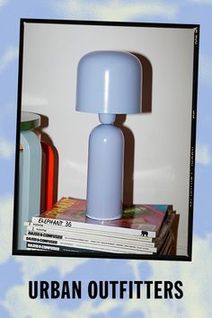 a blue lamp sitting on top of a stack of books