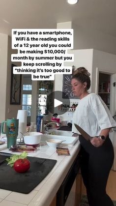 a woman standing at a kitchen counter with a knife in her hand and an open book on the counter