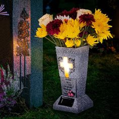 a vase with flowers in it sitting next to a grave