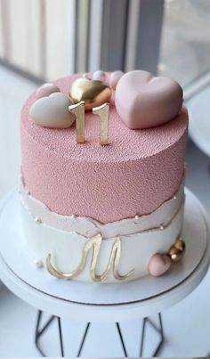 a pink and white cake sitting on top of a table