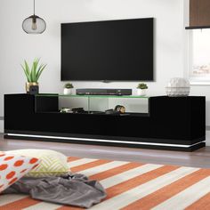 a living room with a large flat screen tv on top of a black entertainment center