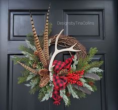 a wreath with deer antlers, pine cones and berries