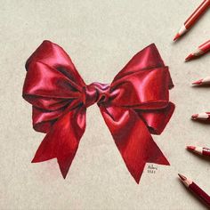 a drawing of a red bow with crayons next to it