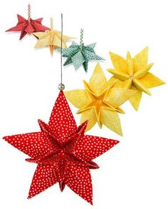 three paper stars hanging from strings with polka dotes on them, one red and one yellow