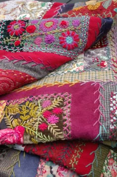 a pile of different colored fabrics on top of each other in various patterns and colors