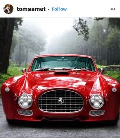 a red sports car parked in front of trees