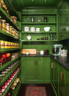 a green pantry filled with lots of food and cooking utensils on the shelves