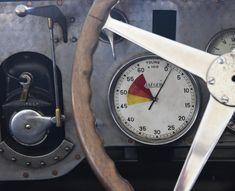 an old car dashboard with gauges and steering wheel