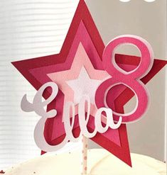 a pink and white cake topped with a star shaped number 8 on top of it