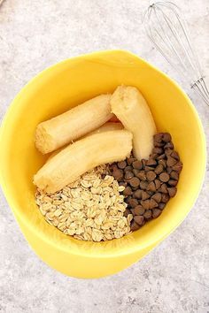 a yellow bowl filled with oats, bananas and chocolate chips