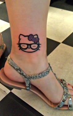 a woman's foot with a tattoo of a hello kitty on her left ankle