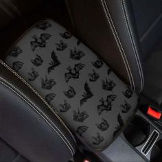 a car seat with bats on it and black leather trims in the center console