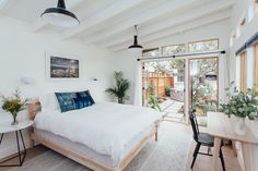 a bedroom with a bed, table and chairs in it's center area is shown