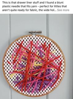 a cross stitch pattern with red and yellow yarn in it on a white wall hanging