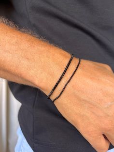 Elevate your style with our men's Black-tone stainless steel chain bracelet. Crafted from durable stainless steel, this bracelet is resistant to corrosion and tarnish, ensuring long-lasting shine and reliability. Features: - Material: Stainless Steel - Color: Black-Tone - Sizes: Available in various lengths for a perfect fit This bracelet is perfect for both everyday wear and special occasions, easily pairing with other accessories and jewelry. The secure clasp ensures comfort and safety. Add a Minimalist Adjustable Durable Bracelet, Durable Black Bracelet Jewelry, Black Durable Bracelet Jewelry, Durable Black Braided Bracelets As Gift, Durable Black Braided Bracelet As Gift, Durable Black Braided Bracelet Gift, Everyday Black Box Chain Bracelet, Black Bracelet With Adjustable Chain For Everyday, Adjustable Black Beaded Bracelet