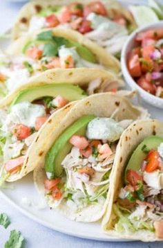 several tacos on a plate with salsa and avocado