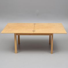 a wooden table with a cross on the top is shown in front of a gray background