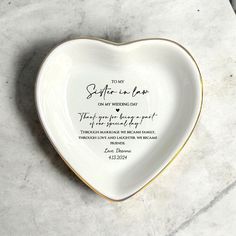 a heart shaped dish with a poem written on the front and bottom, sitting on a marble surface