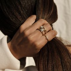 a woman's hand with two rings on her fingers