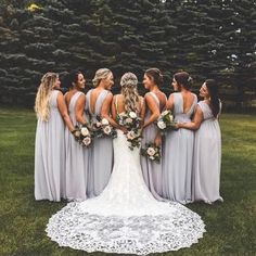 a group of bridesmaids standing in front of some trees