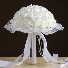 a bridal bouquet with white flowers and pearls