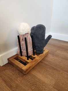 a pair of mitts sitting on top of a wooden holder