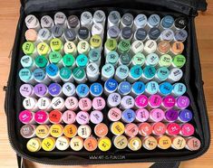 a black bag filled with lots of different colored markers and writing on top of it