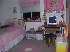 a child's bedroom with two beds, desk and computer on top of it