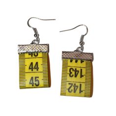 pair of earrings with measuring tape on them