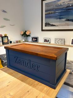 a large blue box sitting on top of a wooden table next to pictures and flowers